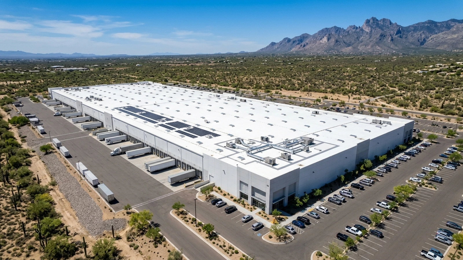 Aerial view of an industrial flat-roof warehouse in Tucson with skylights and solar array mounts